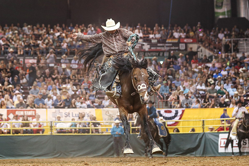 Jesse Kruse competes in saddle bronc with the grandstands in the background at the Nampa, Idaho rodeo in 2022.